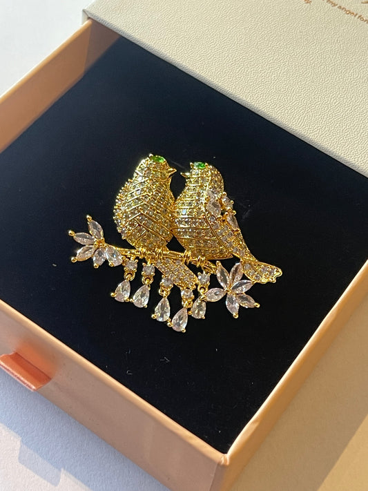 Courting birds in gold brooch